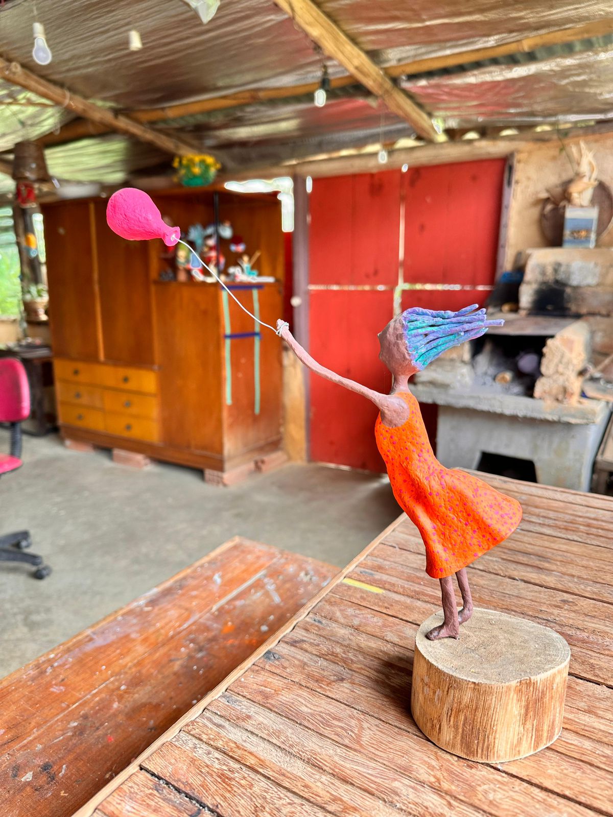 Escultura da menina soltando balão em papel machê