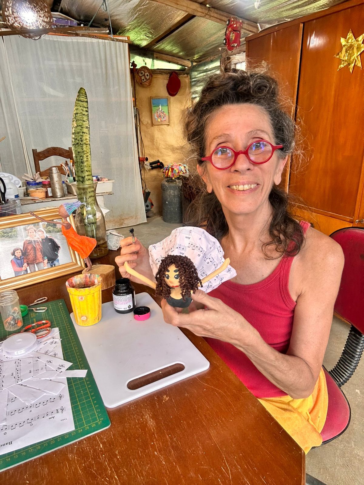 Dolores Montesó em seu ateliê segurando uma escultura em papel machê